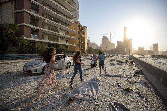 Des habitants fuient les lieux de l'explosion. [Keystone - AP Photo/Hassan Ammar]