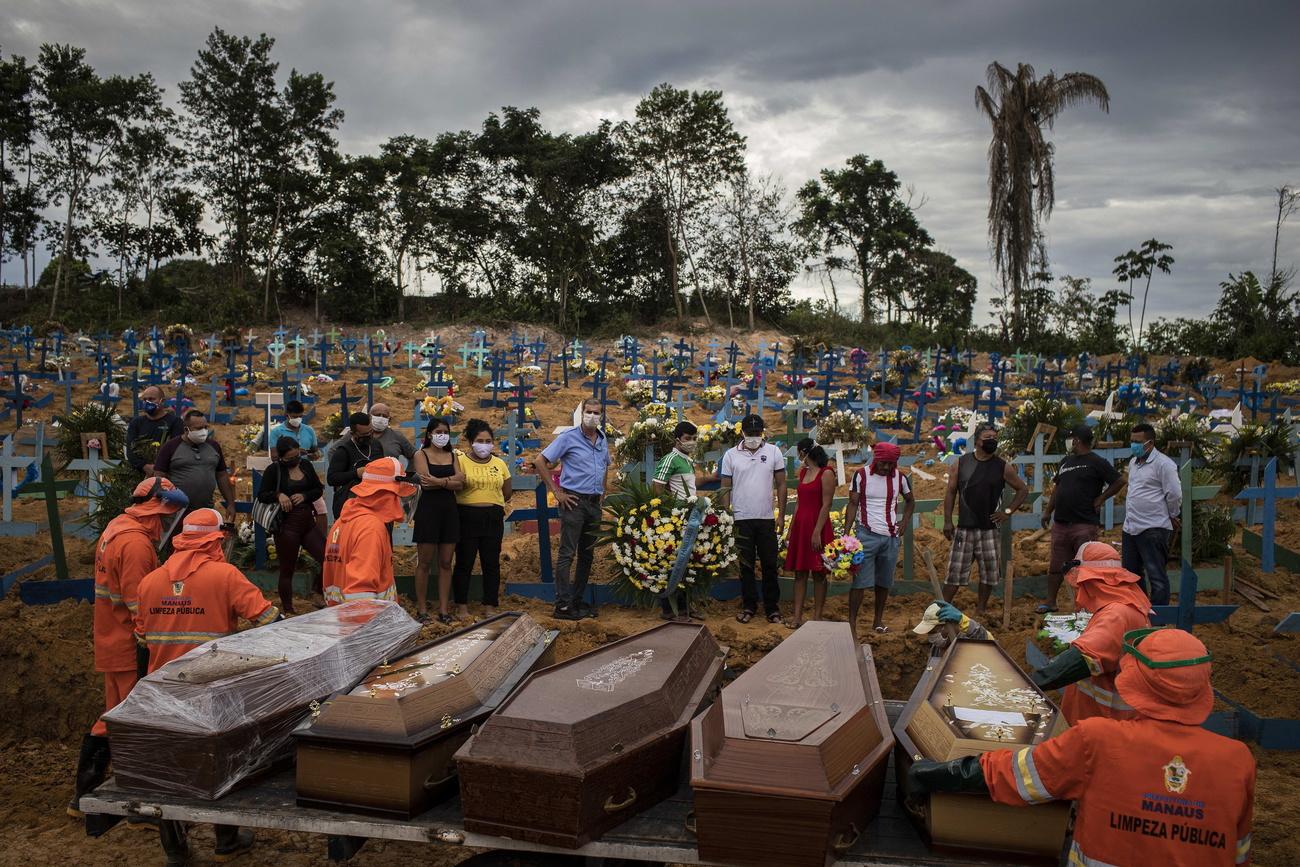 Des gens participent à des enterrements dans une fosse commune d'une nouvelle section du cimetière Nossa Senhora Aparecida, à Manaus. Les victimes du Covid-19 se font de plus en plus nombreuses. Brésil, le 23 avril 2020. [Keystone/epa - Raphael Alves]
