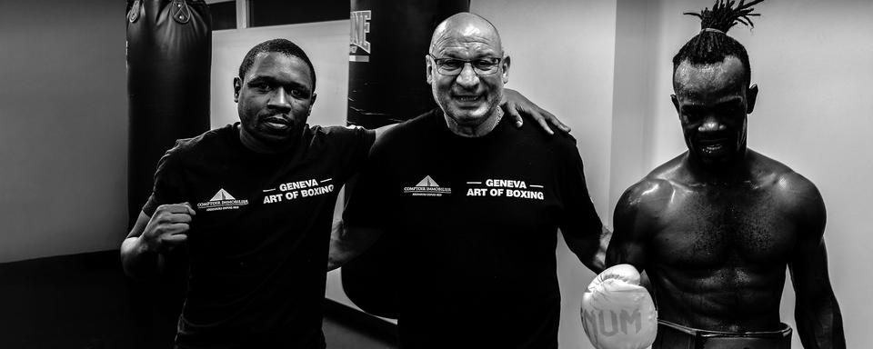 Le boxeur professionnel Patrick Kinigamazi (gauche), son entraîneur Giorgio Costantino (au centre), et Cédric Kassongo (droite). [RTS - Tristan Miquel]