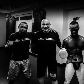 Le boxeur professionnel Patrick Kinigamazi (gauche), son entraîneur Giorgio Costantino (au centre), et Cédric Kassongo (droite). [RTS - Tristan Miquel]