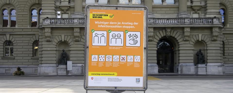 la nouvelle affiche orange de l'OFSP affichant les recommandations pour lutter contre la pandémie. [Keystone - Anthony Anex]