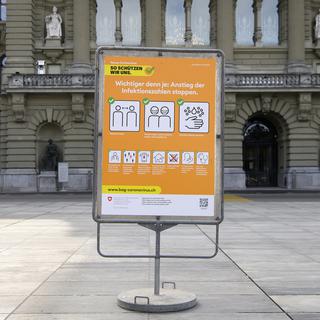 la nouvelle affiche orange de l'OFSP affichant les recommandations pour lutter contre la pandémie. [Keystone - Anthony Anex]