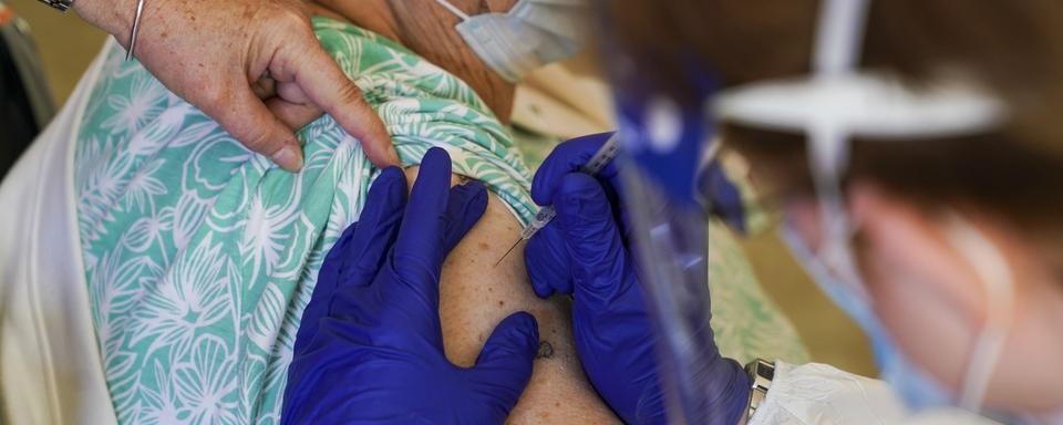 Une dame reçoit une dose de vaccin. [Keystone - Martha Asencio Rhine/AP]