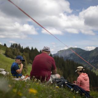 Une famille pique-nique dans les Alpes. [Keystone - Gian Ehrenzeller]