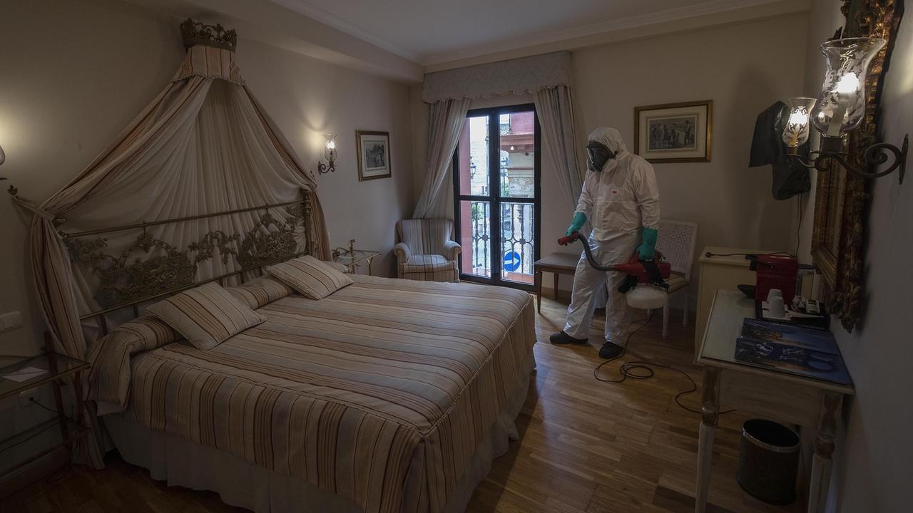 Un nettoyeur désinfecte une chambre d'hôtel à Séville, en Espagne, le 11 mai 2020. [AP/Keysytone - Miguel Morenatti]