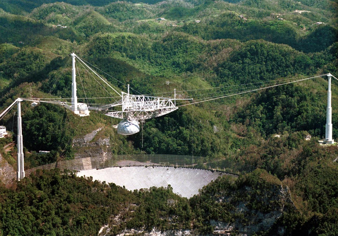 Le radiotélescope d'Arecibo comporte 28'000 plaques d'aluminium qui permettent aux chercheurs d'écouter les sons de l'espace. Image datant d'octobre 1998. [Keystone/AP photo - Lynne Sladky]