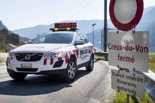 La police neuchâteloise fait barrage aux véhicules à Noiraigue, 10.04.2020. [Keystone - Jean-Christophe Bott]