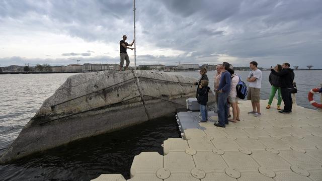 Le public profite d'une passerelle flottante pour accéder à la Pierre du Niton à Genève. [Keystone - Martial Trezzini]