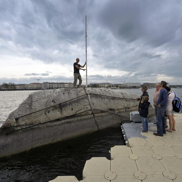 Le public profite d'une passerelle flottante pour accéder à la Pierre du Niton à Genève. [Keystone - Martial Trezzini]