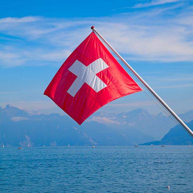 Un drapeau suisse devant le lac Léman. [Depositphotos - swisshippo]