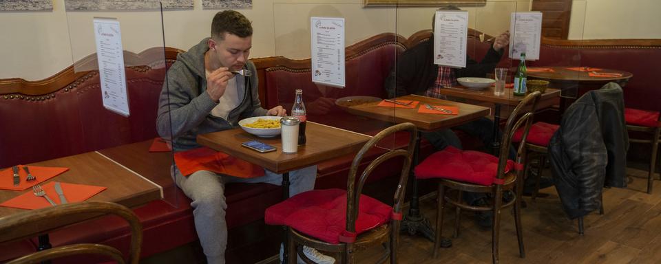 Un client mange à une table d'un restaurant genevois, le 13 mai 2020. [Keystone - Salvatore Di Nolfi]