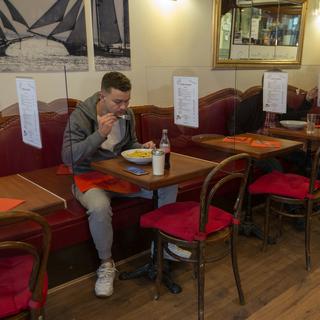 Un client mange à une table d'un restaurant genevois, le 13 mai 2020. [Keystone - Salvatore Di Nolfi]