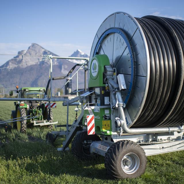 Les agriculteurs doivent déjà commencer à arroser les champs (ici à Baz Ragaz). [Keystone - Gian Ehrenzeller]