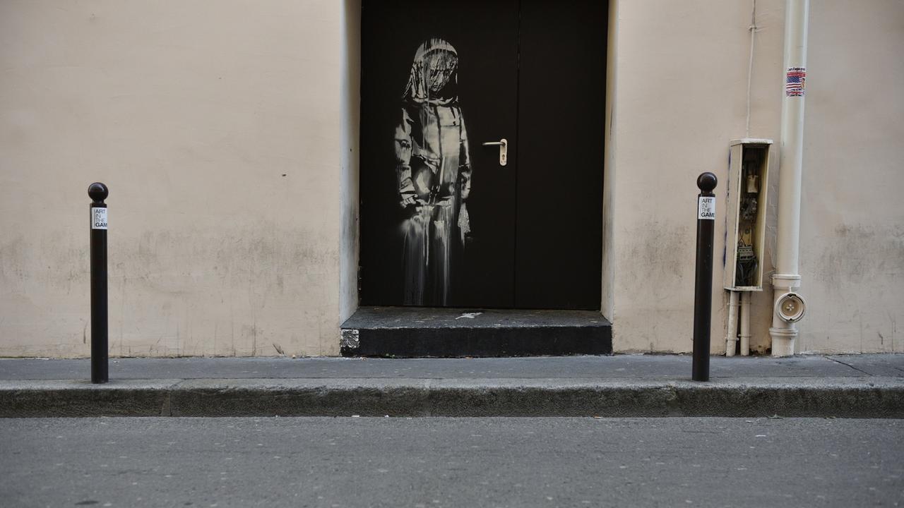 L'oeuvre attribuée à l'artiste Banksy, représentant une jeune fille triste, avait été volée en 2019. [EPA/Keystone - Julien de Rosa]
