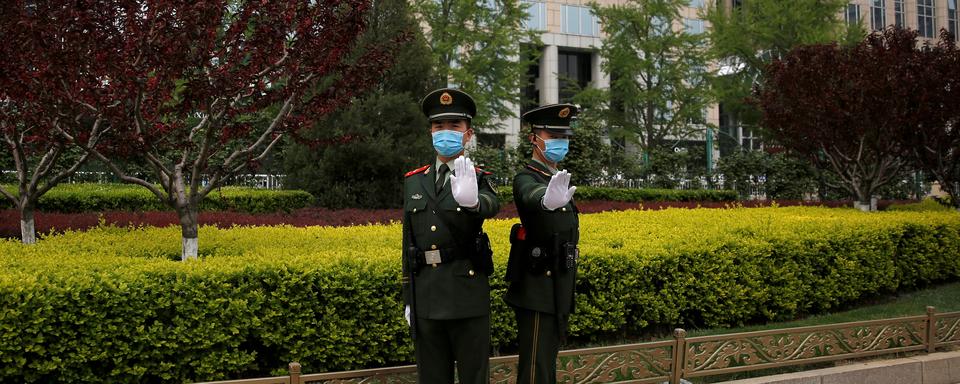 Deux soldats chinois dans une avenue de Pékin, le 15 avril 2020. [Reuters - Tingshu Wang]