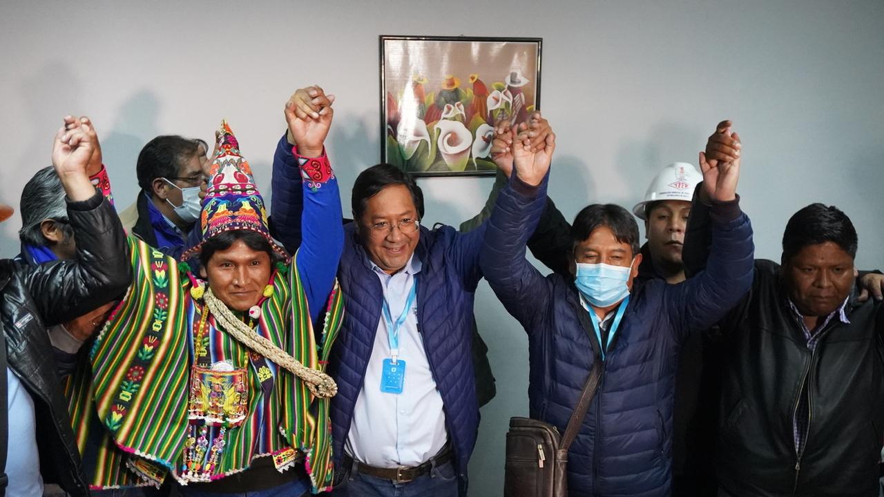 Luis Arce (au centre) a remporté la présidentielle bolivienne au premier tour, en compagnie de son vice-président David Choquehuanca (à droite). [Keystone - Stringer]