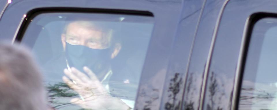 Donald Trump est sorti en voiture saluer ses partisans réunis devant le centre médical militaire national Walter Reed, le 4 octobre 2020. [Keystone/AP photo - Anthony Peltier]