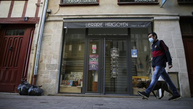 Un homme promène son chien à Bayonne le 30 octobre 2020, alors que la France est soumise à un nouveau confinement. [Keystone - AP Photo/Bob Edme]