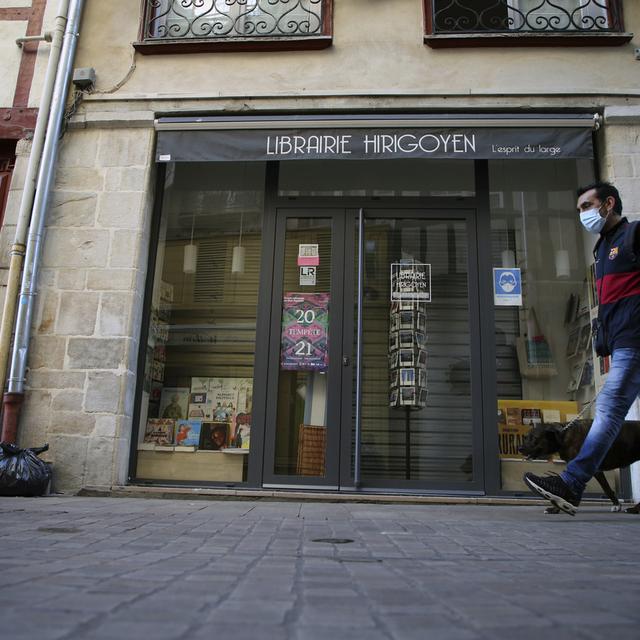 Un homme promène son chien à Bayonne le 30 octobre 2020, alors que la France est soumise à un nouveau confinement. [Keystone - AP Photo/Bob Edme]