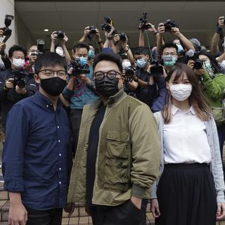 De gauche à droite, Joshua Wong, Ivan Lam et Agnes Chow. Les trois célèbres militants prodémocratie hongkongais ont été condamnés à des peines d'emprisonnement. Photo prise à Hong Kong le 23 novembre 2020. [Keystone/AP photo - Vincent Yu]