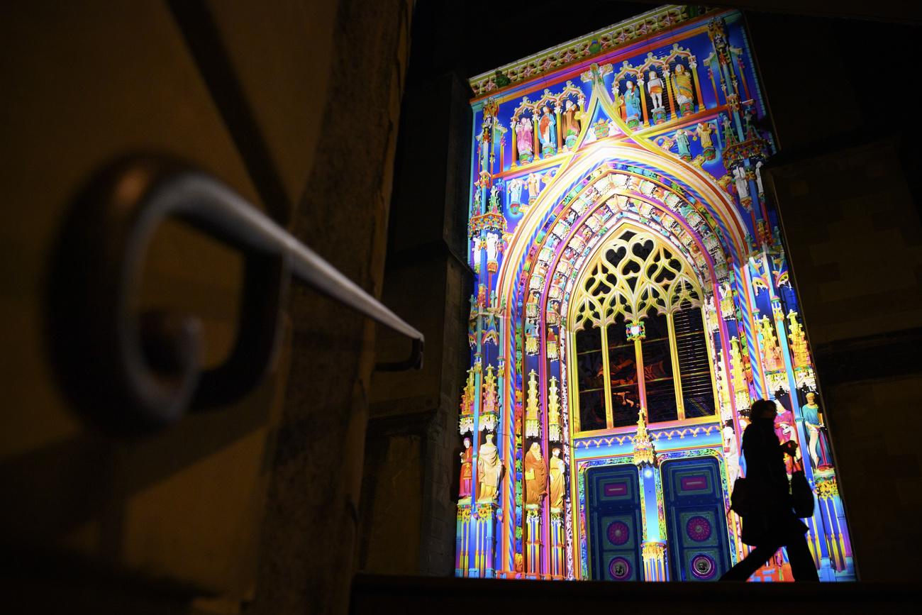 A la cathédrale, l'artiste français Patrice Warrener met en lumière le portail Montfalcon. [Keystone - Laurent Gillieron]