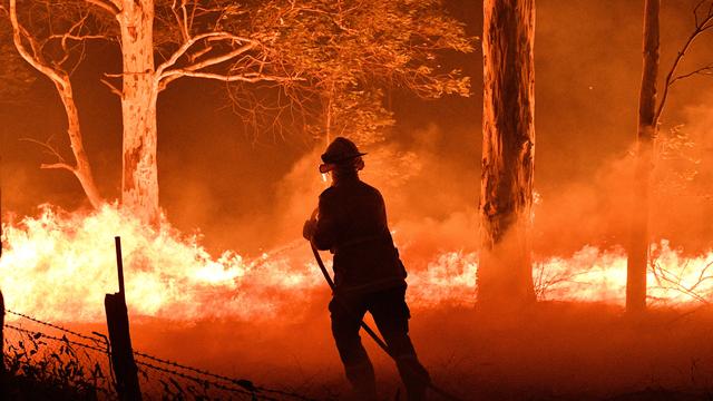 Un pompier tente d'éteindre un incendie de forêt en Australie, le 31 décembre 2020. [AFP - SAEED KHAN]