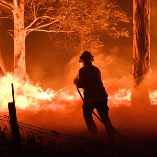 Un pompier tente d'éteindre un incendie de forêt en Australie, le 31 décembre 2020. [AFP - SAEED KHAN]