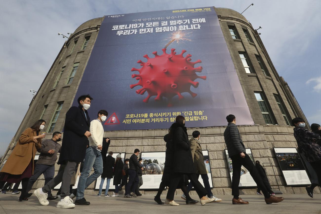 "Nous devons arrêter avant que le Covid-19 n'arrête tout", proclame cette affiche à Séoul, le 25 novembre 2020. [Keystone/AP photo - Ahn Young-joon]