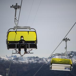 Un skieur portant un masque, le 25 octobre à Davos. [Keystone - Gian Ehrenzeller]
