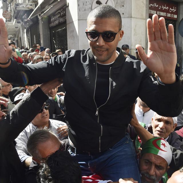 Une photo du journaliste Khaled Drareni, le 6 mars, acclamé par les manifestants après une première arrestation par la police. [AFP - Ryad Kramdi]