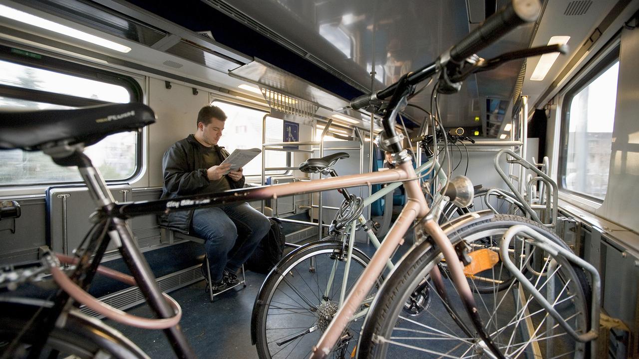 Un homme dans le compartiment destiné aux vélos dans un train CFF. [Keystone - Gaetan Bally]