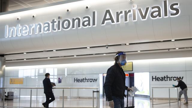 Le premier jour des mesures de quarantaine imposée aux voyageurs, un passager arrive masqué au terminal 2 de l'aéroport de Heathrow à Londres. [Keystone - AP Photo/Matt Dunham]