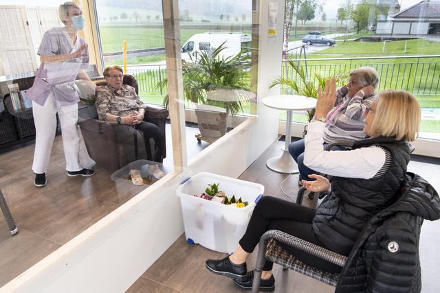 Deux filles rendent visite à leur mère, résidente du home Le Foyer, dans le canton de Neuchâtel. [Keystone - Laurent Gillieron]