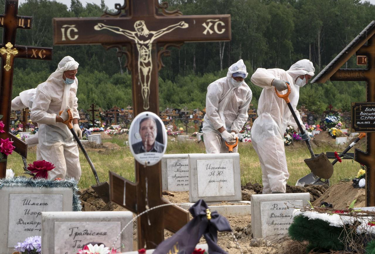 Des fossoyeurs creusent une tombe dans la section réservée aux victimes du Covid-19 dans le cimetière de Kolpino, en-dehors de Saint-Petersbourg. Russie, le 30 juin 2020. [Keystone/AP photo - Dmitri Lovetsky]