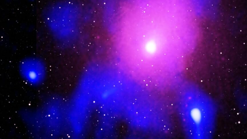 Ce qui reste de l'explosion la plus formidable de l'Univers, due à un trou noir supermassif, dans l'amas d'Ophiuchus. En rose, les rayons-X; en bleu, les ondes radio; en blanc, l'infrarouge. [Radio: NCRA/TIFR/GMRT; Infrared: 2MASS/UMass/IPAC-Caltech/NASA/NSF - X-ray: Chandra: NASA/CXC/NRL/S. Giacintucci, et al., XMM-Newton: ESA/XMM-Newton]