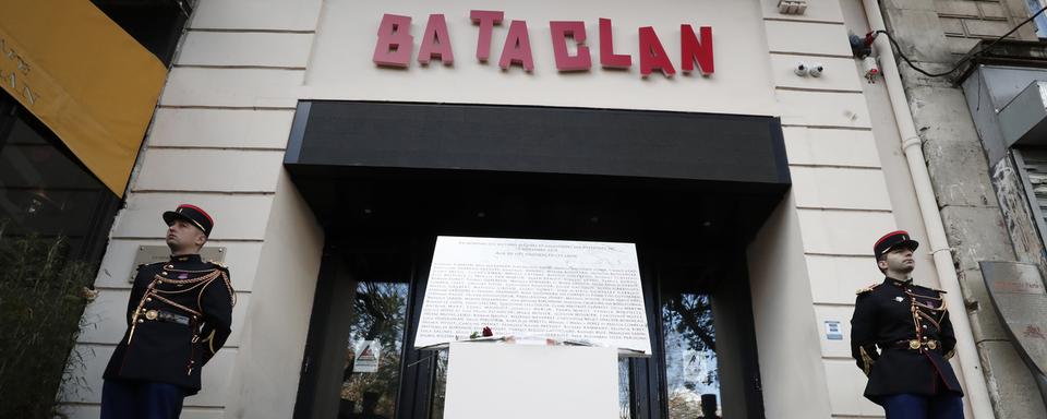 Une plaque commémorative et des fleurs déposées devant le Bataclan à Paris. [Keystone/AP - Benoît Tessier]