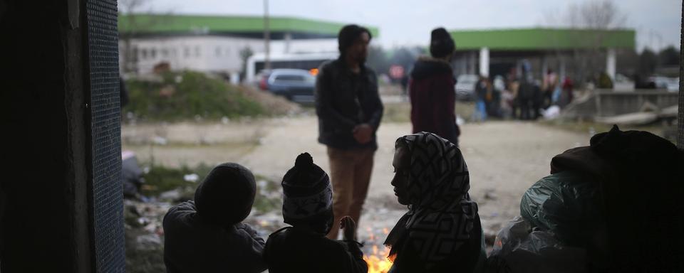 Des migrants tentent de se réchauffer dans une maison abandonnée près de la frontière gréco-turque. [AP Photo/Keystone - Emrah Gurel]