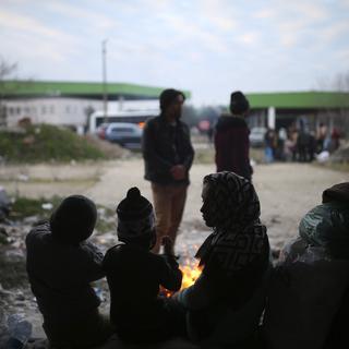 Des migrants tentent de se réchauffer dans une maison abandonnée près de la frontière gréco-turque. [AP Photo/Keystone - Emrah Gurel]