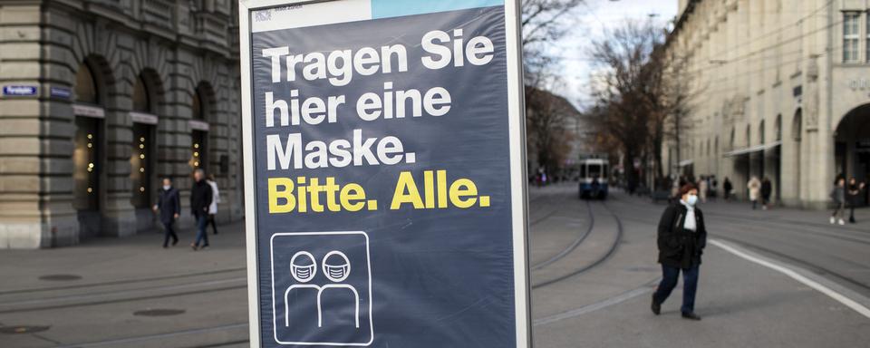 Un panneau demandant à tout le monde de porter un masque sur la Paradeplatz de Zurich. [Keystone - Alexandra Wey]