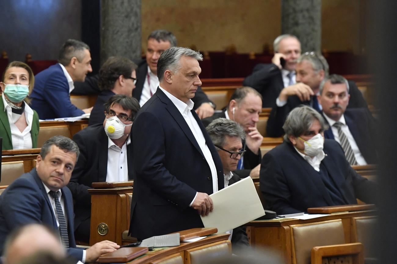 Les dispositions de la "loi coronavirus" permettent à Viktor Orban (debout), le dirigeant hongrois, de prolonger indéfiniment l'état d'urgence en vigueur depuis le 11 mars, sans demander l'aval du Parlement. [Keystone/epa - Zoltan Mathe]