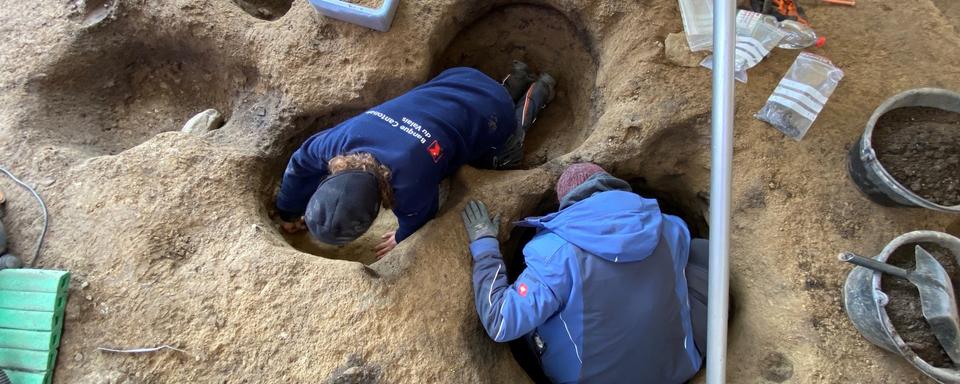 Vue zénithale des archéologues en train de vidanger des structures de type fosses et trous de poteaux.  
Image à dispo dans dossier de presse canton du valais
Archeodunum OCA
Canton du Valais [Canton du Valais - Archeodunum OCA]