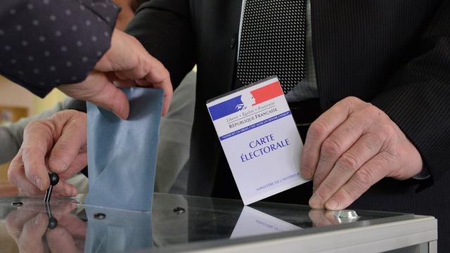 Un électeur place son bulletin de vote dans l'urne. [Keystone/EPA - Caroline Blumberg]