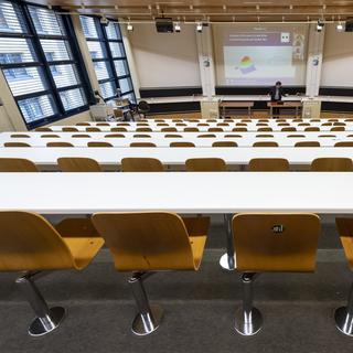 Un professeur donne un cours par vidéoconférence à ses étudiants depuis un auditoire vide de l'EPFL, le 13 mars 2020. [Keystone - Jean-Christophe Bott]