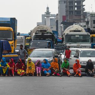 Des travailleurs de l'industrie du vêtement bloquent une route à Dacca, le 15 avril 2020, pour revendiquer le paiement de leurs salaires impayés. [AFP - Munir Uz Zaman]