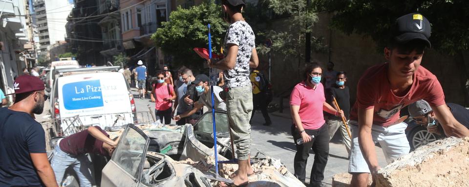 De jeunes Libanais aident dans les décombres de Beyrouth. [Keystone - EPA/Ibrahim Dirani / Dar al Mussawir]