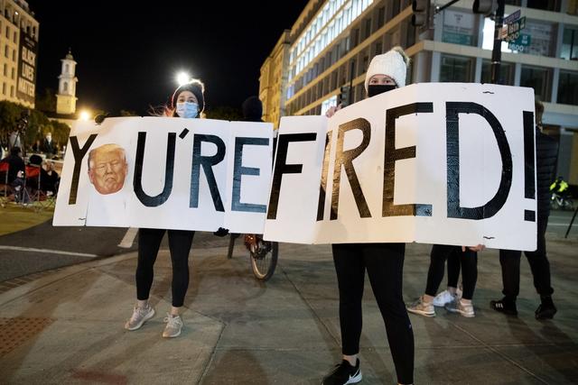 "T'es viré!" proclament les pancartes de ces deux manifestantes, non loin de la Maison Blanche, à Washington DC, le 4 novembre 2020. [Keystone/epa - Michael Reynolds]