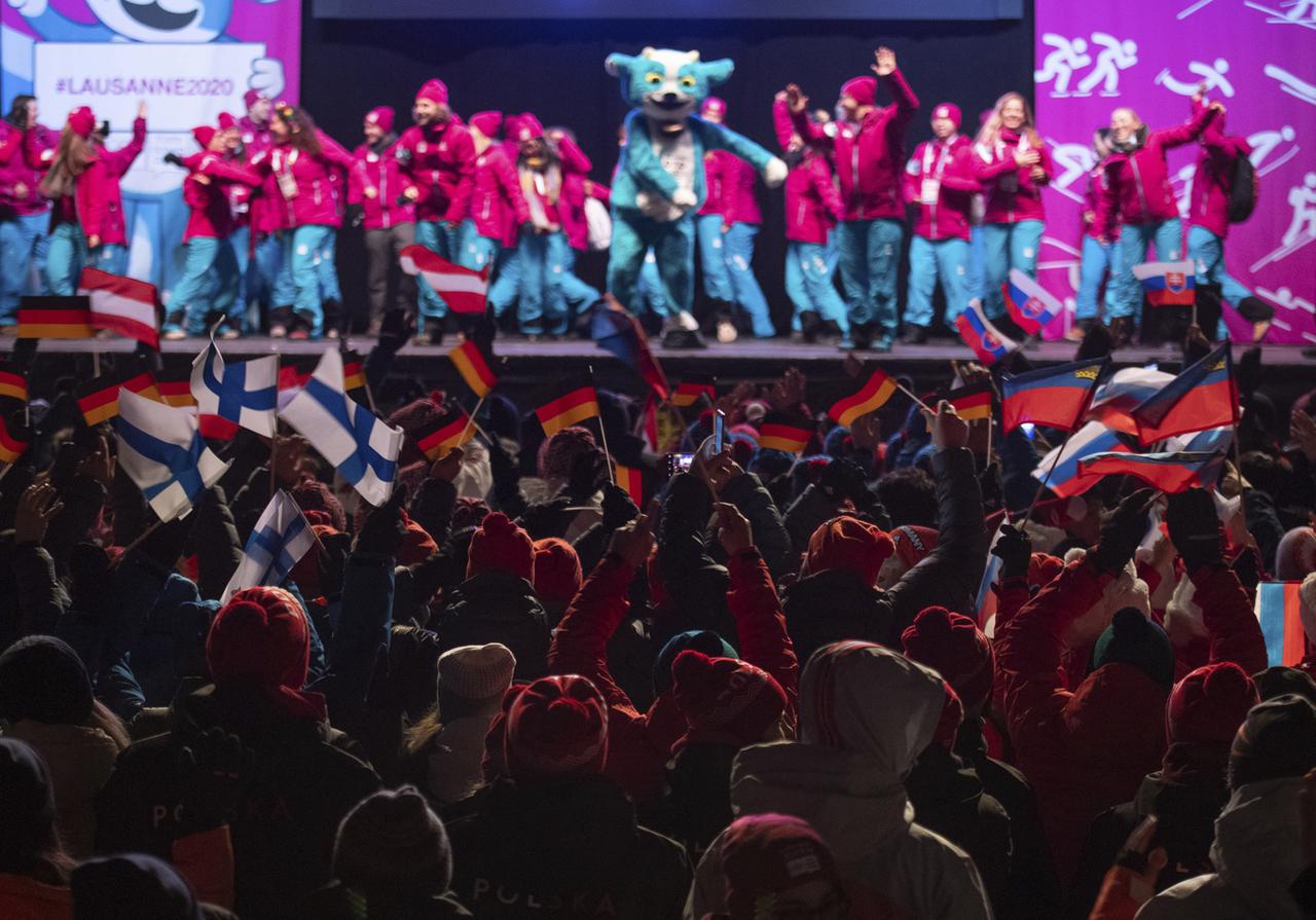 Yodli, la mascotte des JOJ, dansent au milieu de jeunes athlètes.