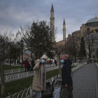 Des touristes portant un masque devant la mosquée Sainte-Sophie à Istanbul en Turquie. [Keystone/AP Photo - Emrah Gurel]