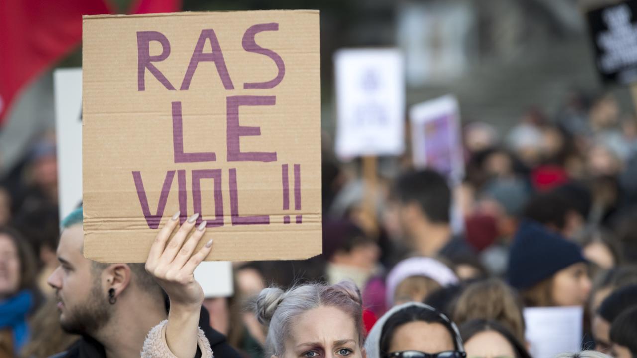 Une femme brandit une pancarte "Ras le viol!!" lors d'une manifestation contre les violences sexistes et sexuelles, le 23 novembre 2019, à Lausanne. [KEYSTONE/Laurent Gillieron]