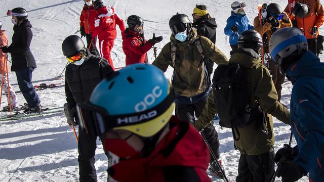 Des skieurs à Verbier portant un masque de protection. [Keystone - Jean-Christophe Bott]